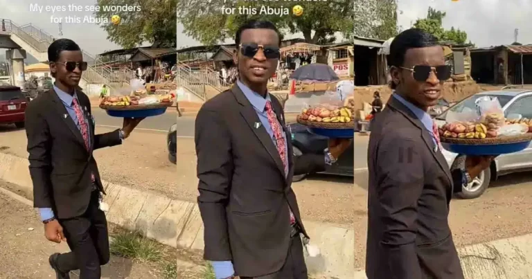 “Even kola man don rebrand” – Man rocks suit to sell kola nuts on Abuja streets